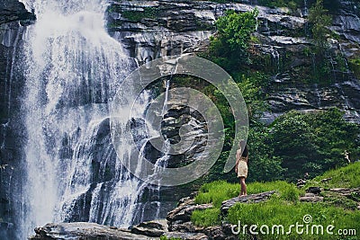Fascinating low angle shot of a female admiring the waterfall in Doi Inthanon park in Thailand Editorial Stock Photo