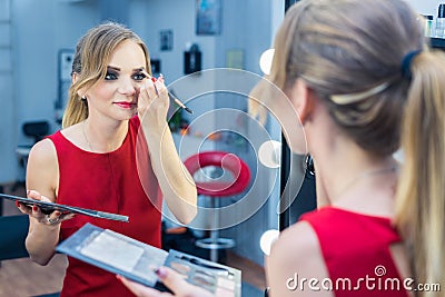 Fashio Portrait of beautiful young girl making make-up near mirror Stock Photo