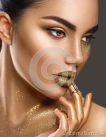 Fashion art makeup. Portrait of beauty woman with golden skin. Shiny professional makeup Stock Photo