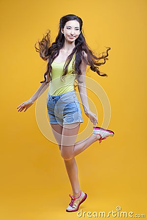 Fashion asian young girl. Portrait on yellow Stock Photo