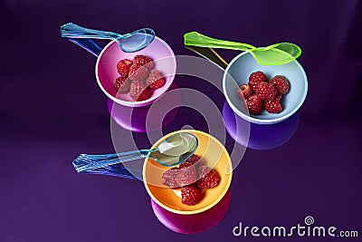 Fashion background with raspberries on multicolored containers Stock Photo