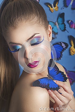 Fashion Beauty Gir with a butterfly on her handl. Gorgeous Woman Portrait. Hairstyle. Make up. Vogue Style. Glamour Girl. Stock Photo