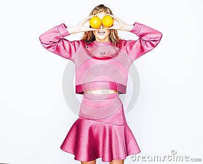 Fashion and beauty. A stunning beauties girl having fun with slices of oranges closing by them eyes. Stock Photo