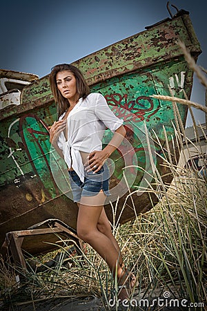 Fashion Caucasian model posing outdoor in front of an old boat Stock Photo