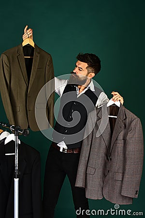 Fashion choice concept. Designer makes choice holding clothes hangers. Stock Photo