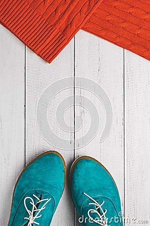 Fashion concept, top view. Casual lifestyle in autumn. Flat Lay. Green women shoes and red knitted sweater on white wood backgroun Stock Photo