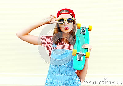 Fashion cool girl is pulling her lips with skateboard over white Stock Photo