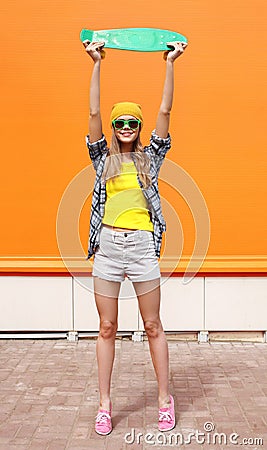 Fashion cool girl in sunglasses and colorful clothes, skateboard Stock Photo