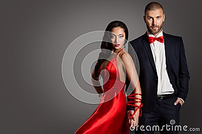 Fashion Couple, Woman and Man Arms Bounded by Ribbon, Red Dress Black Suit Stock Photo