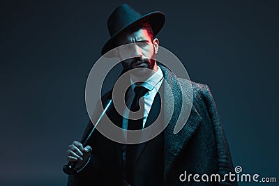 Fashion, criminal and face of man with bat for vintage, retro and Victorian gangster on dark background. Crime aesthetic Stock Photo