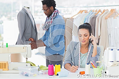 Fashion designer calling and writing Stock Photo