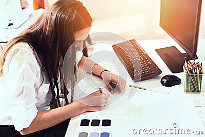 Fashion designer draw or design clothes on the table measuring textile material scissors cutting fabric by young woman designer Stock Photo