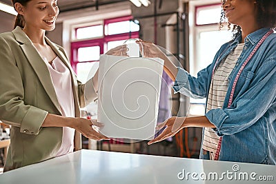 Fashion designer give package with clothes to girl Stock Photo