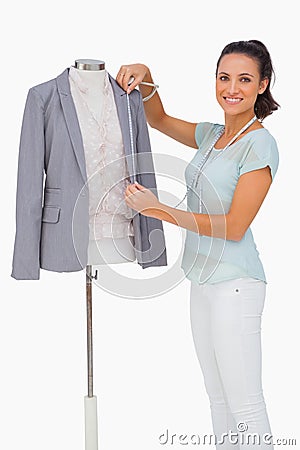 Fashion designer measuring blazer lapel on mannequin and smiling Stock Photo