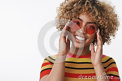 Fashion diva ready for walk. Good-looking stylish and happy african american girl with blond curly hair in trendy round Stock Photo