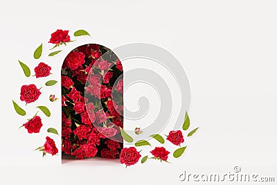 Fashion floral abstract stage with red roses as arch and podium mockup with flying buds and green leaves as flow on white. Stock Photo