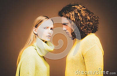 Fashion girl and guy in outlet yellow clothes posing in studio. Fashion couple each other. Stock Photo