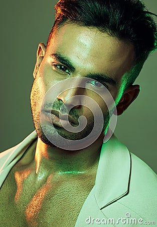 Fashion, green lights and portrait of sexy man from India in studio background creative shoot. Beauty, neon light and Stock Photo