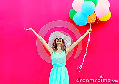 Fashion happy smiling woman with an air colorful balloons is having fun in summer over a pink background Stock Photo