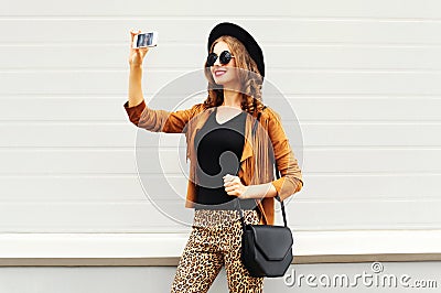 Fashion happy young smiling woman taking photo picture self-portrait on smartphone wearing retro elegant hat, sunglasses Stock Photo