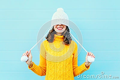 Fashion happy young woman in knitted hat and sweater having fun over colorful blue Stock Photo