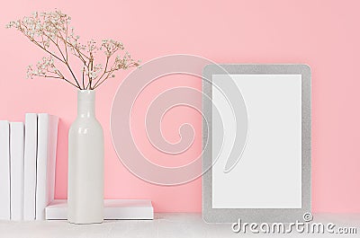 Fashion home interior with silver touch tablet with blank screen and dry flowers in ceramic vase, books on soft pink background. Stock Photo