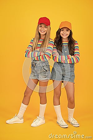 Fashion inspired by the sneaker culture. Happy kids keeping arms crossed with fashion look. Fashion small girls in Stock Photo