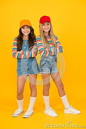 Fashion inspired by the sneaker culture. Happy kids keeping arms crossed with fashion look. Fashion small girls in Stock Photo