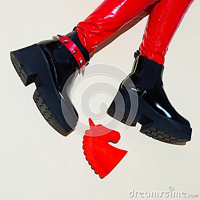 Fashion legs in platform party boots and red leather leggins on minimal background. Stylish clubbing 90s fashion Stock Photo