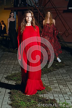 Fashion model in long wide designers dress at night show Stock Photo