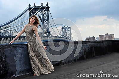 Fashion model posing sexy, wearing long evening dress on rooftop location Stock Photo