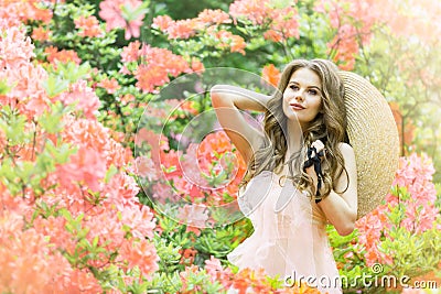 Fashion Model in Rhododendron Flowers, Beautiful Young Woman in Blooming Garden, Outdoor Beauty Portrait Stock Photo