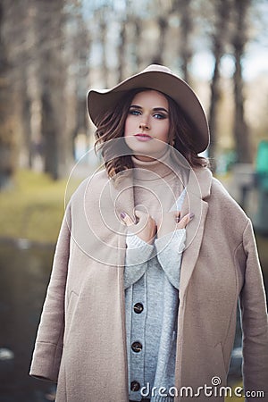 Fashion model woman in season cot and fashionable hat Stock Photo