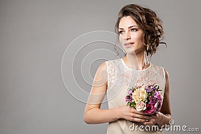 Fashion Models Beauty Portrait with Flowers Bouquet, Beautiful Woman Bridal Makeup and Hairstyle, Girl studio shot on gray Stock Photo