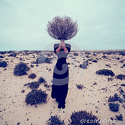 Fashion Photo. Girl in the desert with a bouquet dead branches Stock Photo