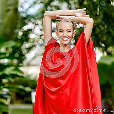 Fashion photo of young magnificent woman in red dress. Outdoor p Stock Photo