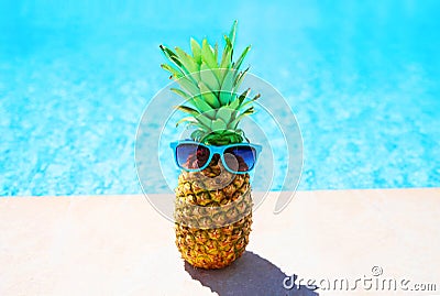 Fashion pineapple with sunglasses on a blue water pool Stock Photo