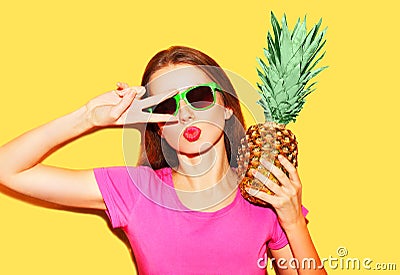 Fashion portrait cool girl in sunglasses and pineapple over yellow Stock Photo