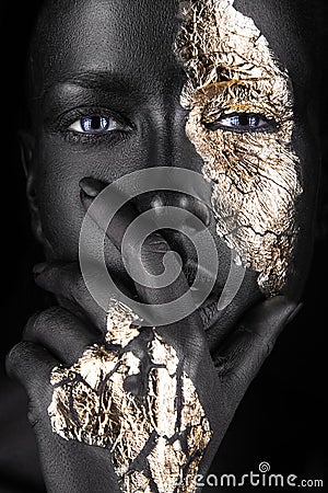 Fashion portrait of a dark-skinned girl with gold Stock Photo