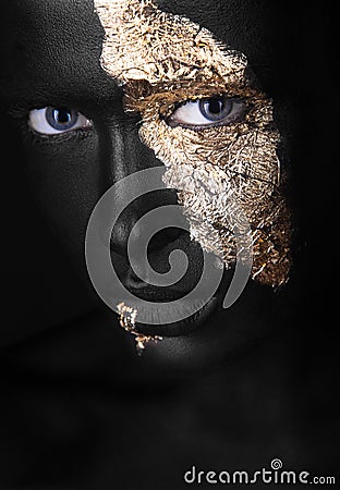 Fashion portrait of a dark-skinned girl with gold make-up. Beauty face. Stock Photo