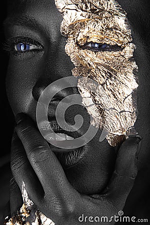 Fashion portrait of a dark-skinned girl with gold make-up. Beauty face. Stock Photo