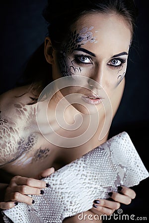 Fashion portrait of pretty young woman with creative make up like a snake Stock Photo