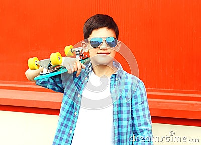 Fashion portrait teenager boy holds a skateboard in sunglasses Stock Photo