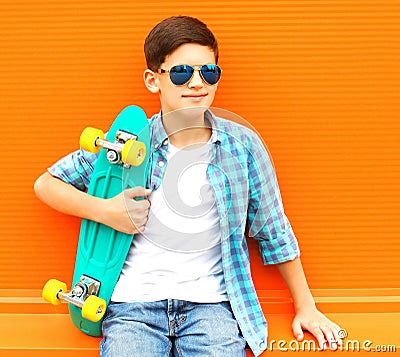 Fashion portrait teenager boy with skateboard wearing a sunglasses Stock Photo