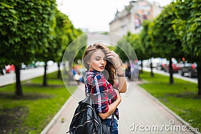 Fashion portrait trendy young woman with backpack in the city simmer Stock Photo