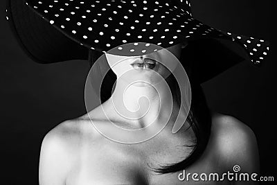 Fashion portrait of a woman with black and white dots hat and pout lips Stock Photo