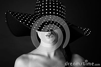 Fashion portrait of a woman with black and white dots hat and pout lips Stock Photo