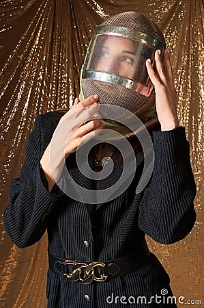 fashion portrait of a woman in a protective mask swordsman. golden background. Stock Photo
