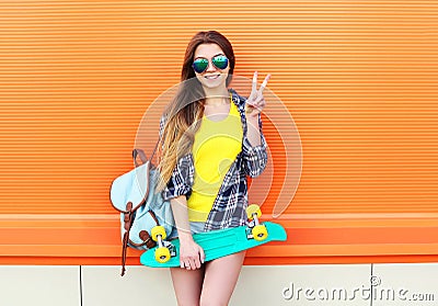 Fashion pretty cool girl wearing a sunglasses, backpack with skateboard having fun Stock Photo