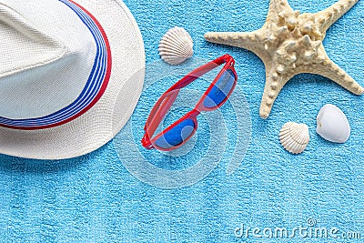 Fashion red glasses, straw hat, starfish, shells on blue beach towel. Concept travel vacation, summer holidays, top view, flat lay Stock Photo